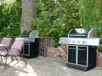 Gas BBQs and outdoor seating in the picnic area beside the pool
