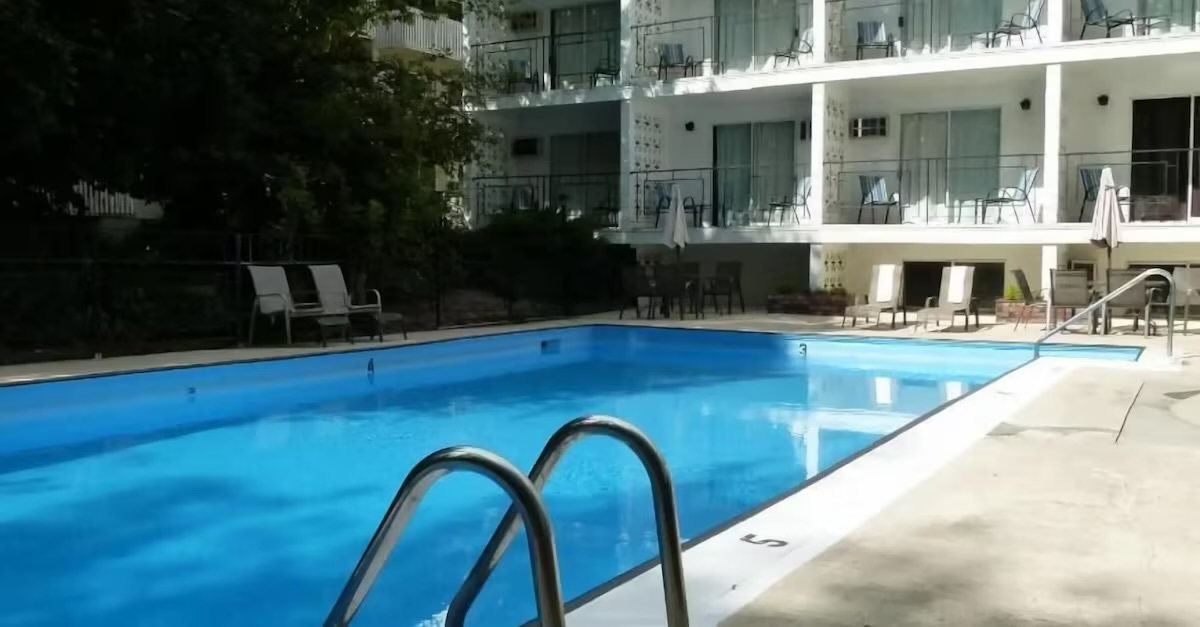 Wide view of the Schell Motel pool with the building wrapping around it